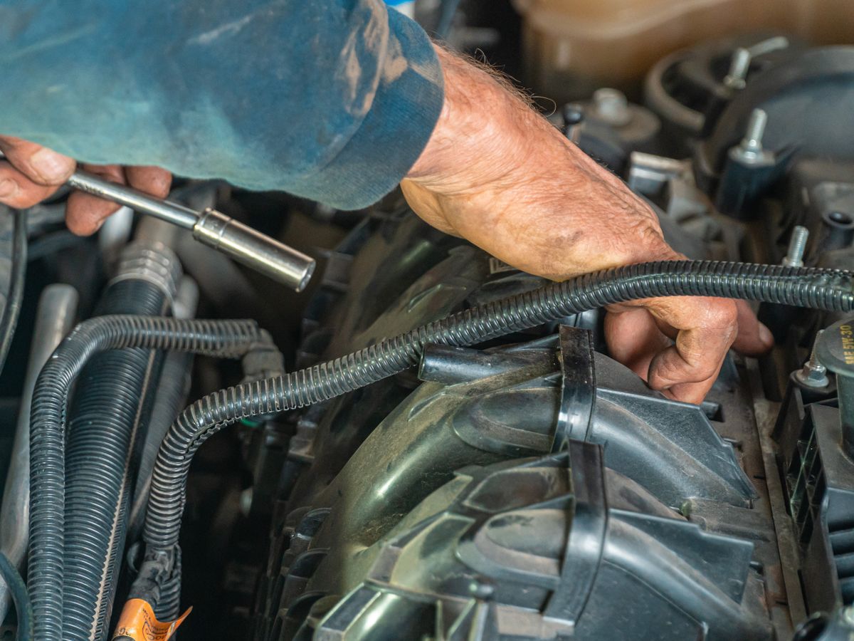 Mecânico a reparar um motor de carro em oficina